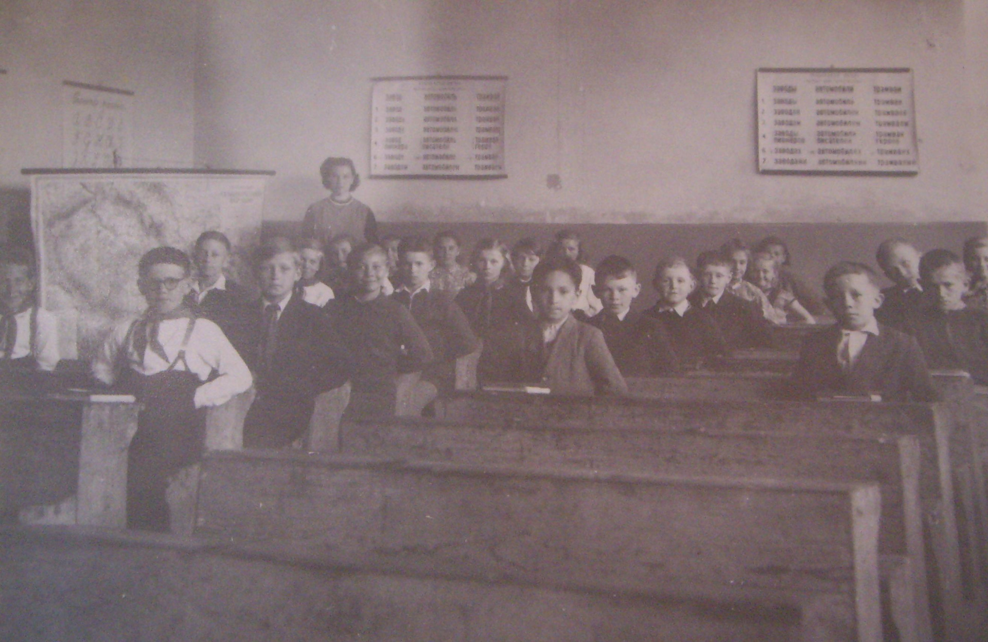 Historická čiernobiela fotografia interiéru starej vidieckej školy v Drahovej s lavicami a žiakmi.